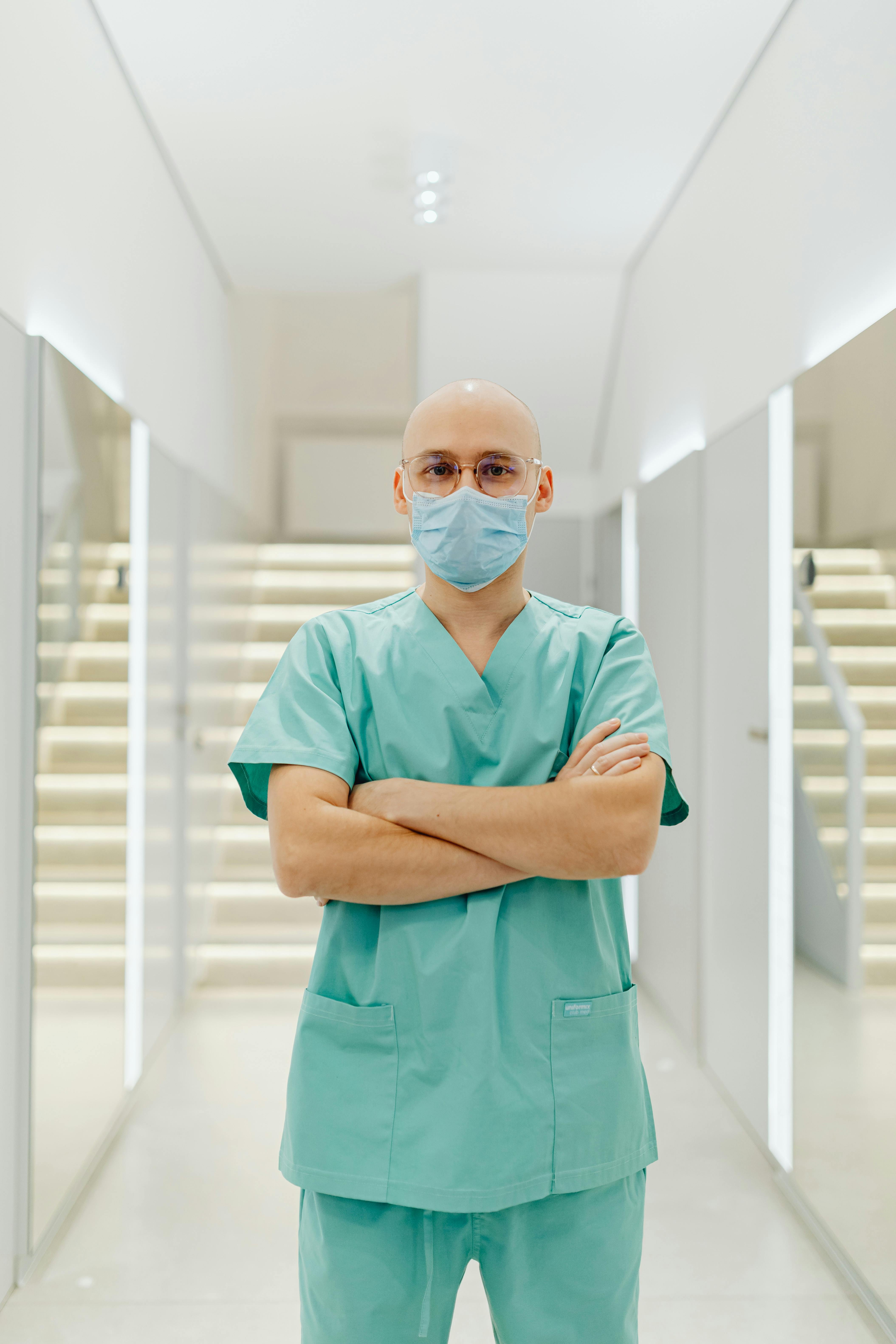 Nurse in scrubs standing confidently in a hospital corridor